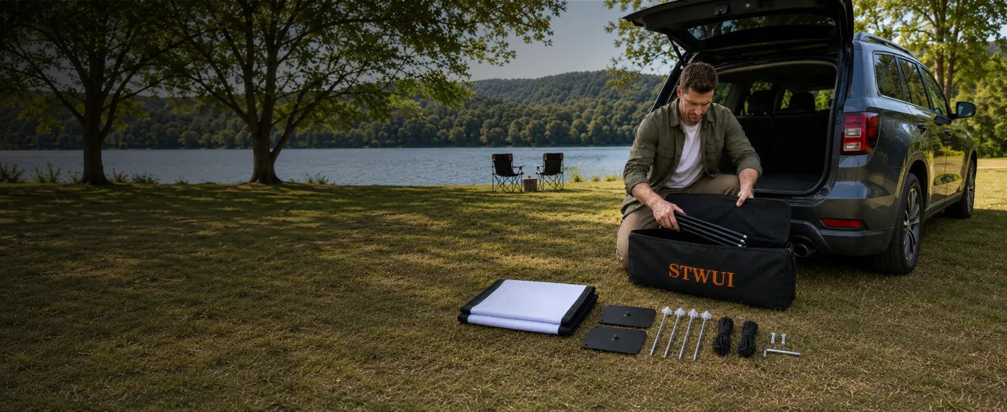 Man unpacking a STWUI projector screen carry bag with all accessories laid out on grass beside a lake